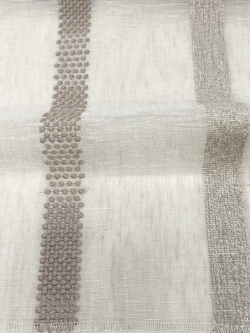 Sheer linen fabric with vertical dotted and textured stripe embroidery in beige tones, shown in close-up view.
