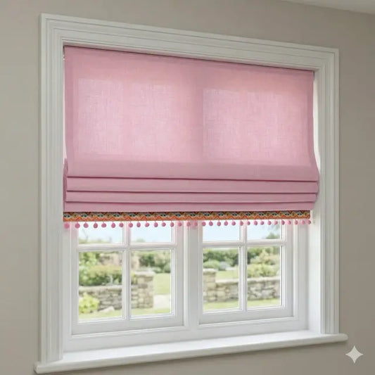 Window with pink roman blind and decorative trim on a light gray wall.