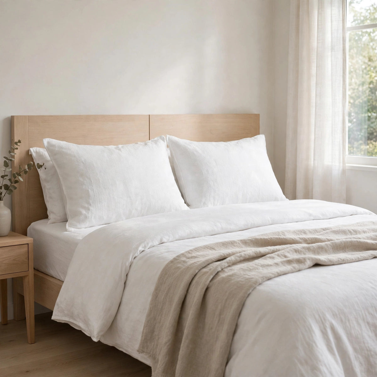White tumbled medium weight linen blend fabric by the yard made into bed pillow covers in a bright bedroom
