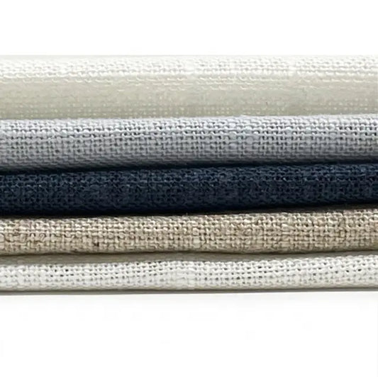 Stack of linen fabric swatches in various neutral colors on a white background