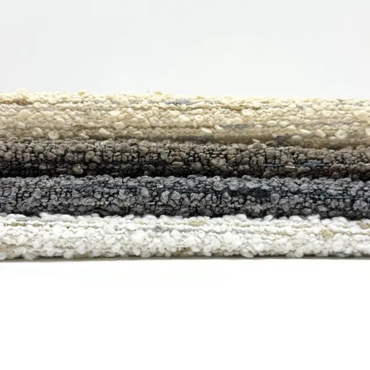 Stack of textured fabric swatches in various colors on a white background