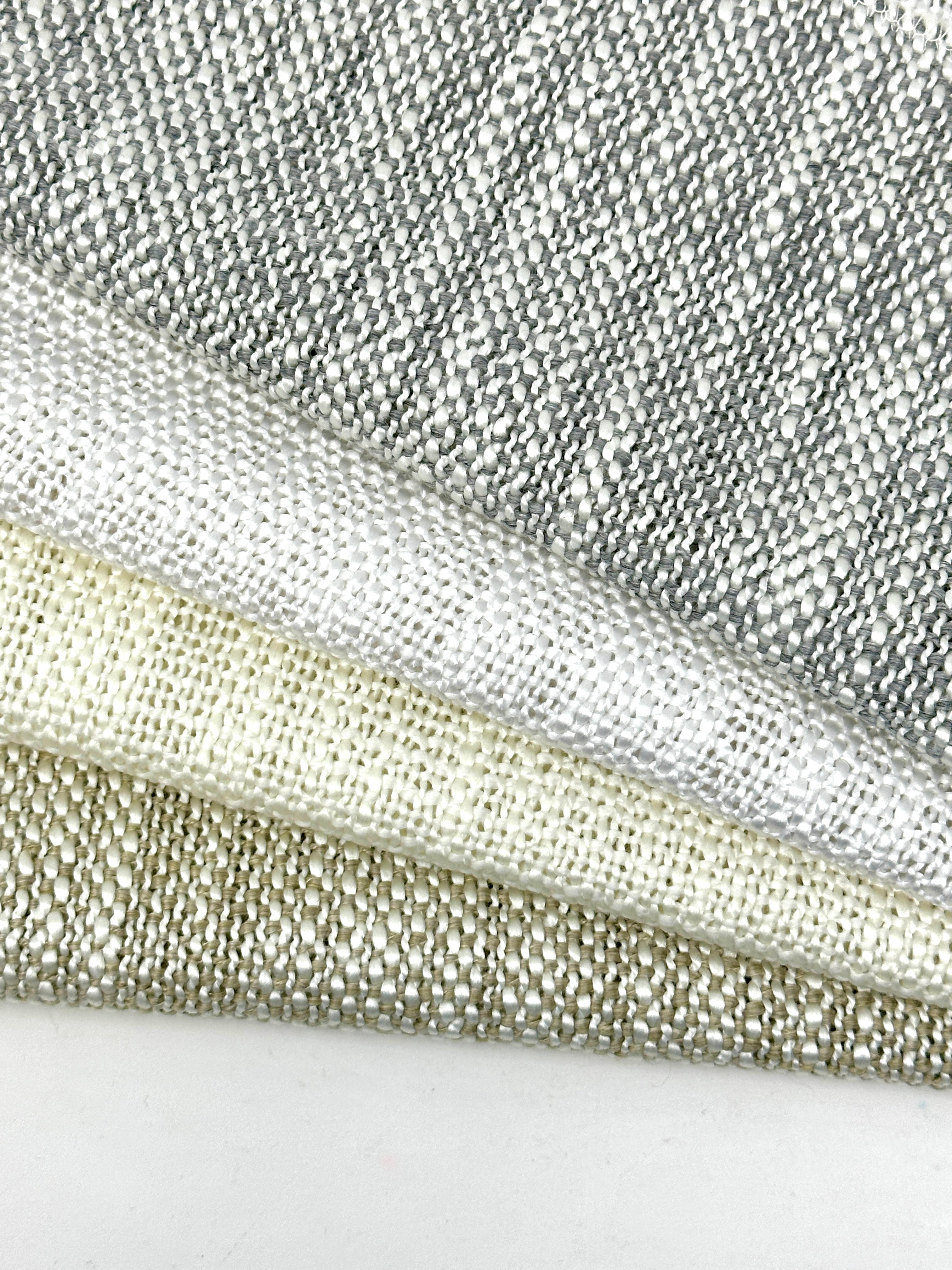 Close-up of neutral-toned medium weight faux blend linen sheer fabric, stacked to show texture and weave.
