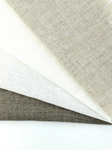 Natural linen fabric swatches in neutral tones for drapery and home décor.