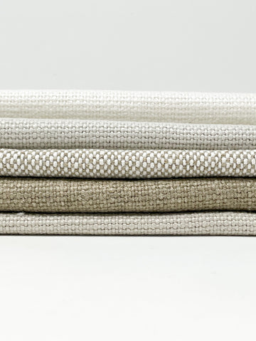 Stack of neutral-toned medium heavy weight 100% linen weave fabrics, ideal for upholstery or home decor, shown in 55-inch width.
