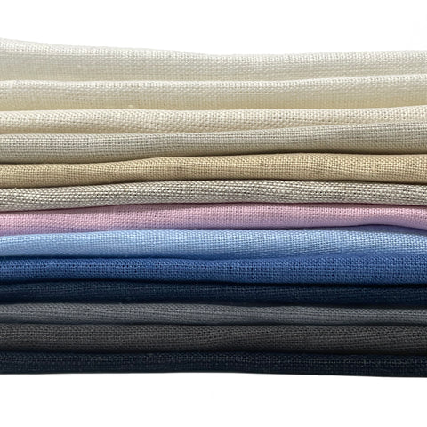 Stack of premium 100% natural linen fabrics in multiple colors. Ideal for curtains, drapery, table settings, and upholstery projects.