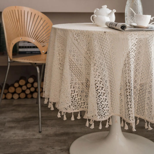 Round table with a lace tablecloth, teapot, and newspaper in a cozy room.