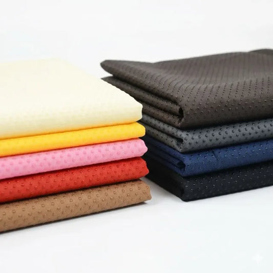 Stack of folded fabrics in various colors on a white background