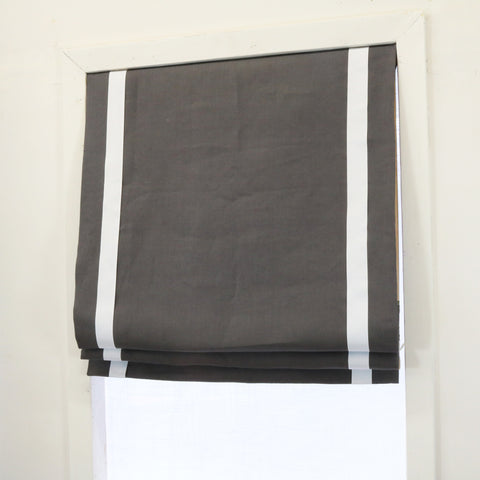 Dark grey 100% linen custom made flat roman shade with white decorative trims on the sides.