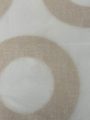 Linen fabric with large tan embroidered geometric circle pattern on white background.