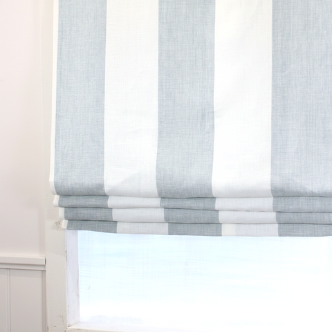 Roman blinds with a striped pattern in shades of ciel and white.