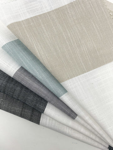 100% natural  linen Roman shades featuring 5-inch wide stripes in a stylish arrangement of natural, ciel, grey, smoke grey, and indigo colors. The shades are displayed side by side, creating a visually appealing and versatile window treatment