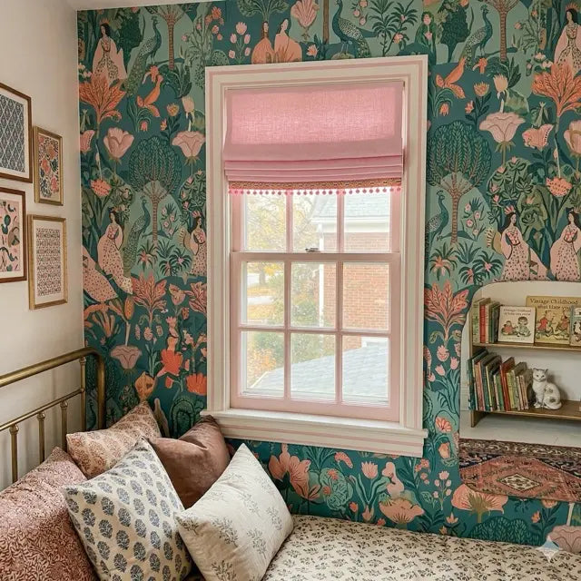 Room interior with floral wallpaper, window with pink roman shade and decorative pillows.