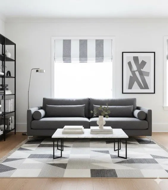 Modern living room with white & grey wide stripe linen flat roman shade, a gray sofa, coffee table, and abstract art on the wall.

