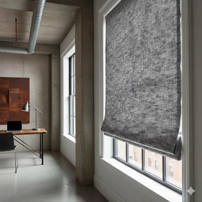 Modern office space with a large window and gray sheer linen roman shade.