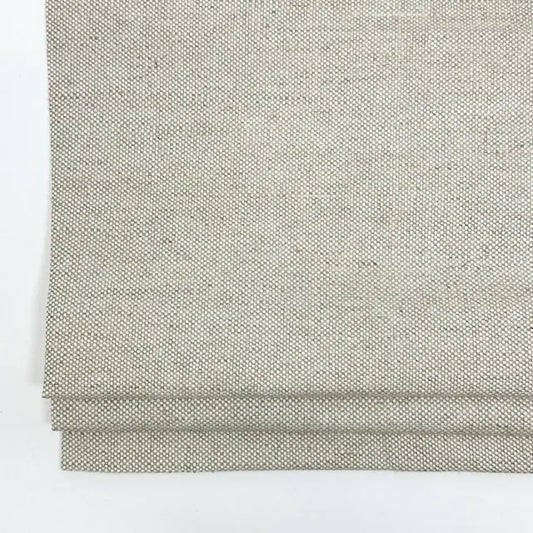 folded oatmeal color linen fabric on a white background
