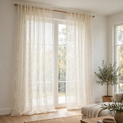 Natural rustic open weave sheer linen curtains hanging in a bright living room