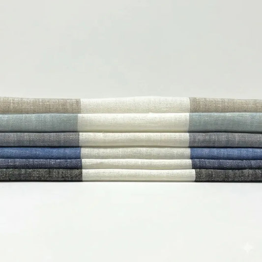 Stack of folded fabric swatches in various shades of blue and gray on a light gray background
