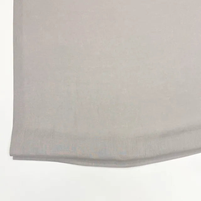 A close-up of a light gray fabric, showing its fine woven texture and folded hem against a plain white background.