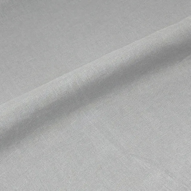 A close-up of light gray fabric with a soft diagonal fold showing the material texture.
