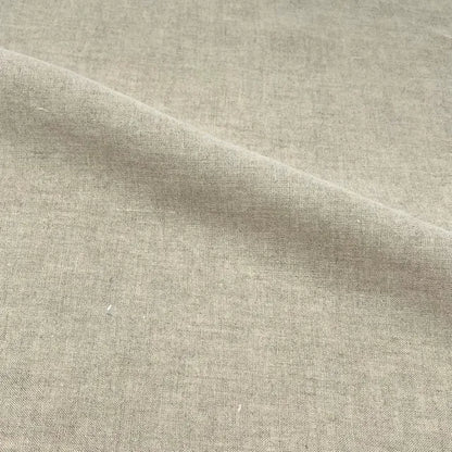 A close-up of a light beige linen fabric with a visible diagonal fold showing its woven texture.