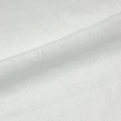 A close-up of white textured fabric with a soft diagonal fold.