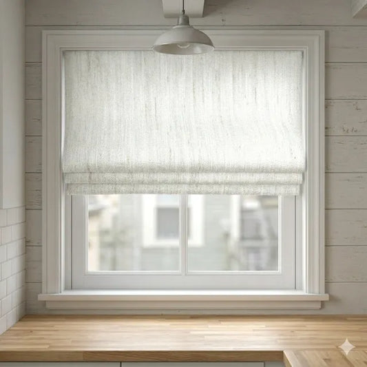 Window with a textured linen roman shade in a room with wooden flooring and white walls.