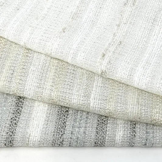 Close-up of textured linen fabric with a neutral color palette on a white background
