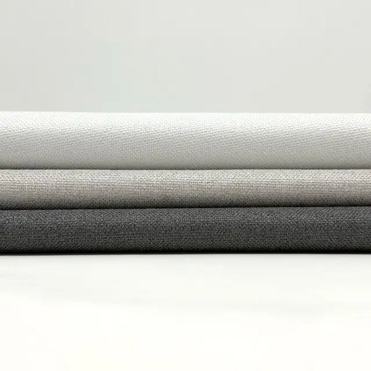 Three rolls of fabric in gray, black, and white on a white background
