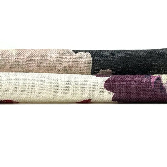 Close-up of fabric swatches in beige, black, and purple on a white background