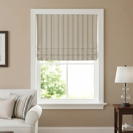 A beige and white striped linen roman shade with a subtle plaid border, shown installed on a white-framed window in a styled living room setting.