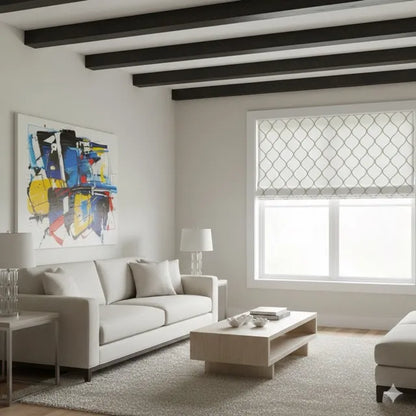 A modern living room with a light beige sofa, a low wooden coffee table, a large abstract painting on the wall, and a window with a white roller blind featuring a gray geometric lattice pattern.