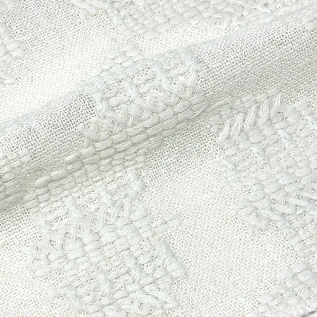 Close-up of textured white fabric with a diagonal pattern