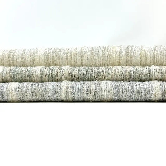 Three folded fabric swatches in neutral colors on a white background