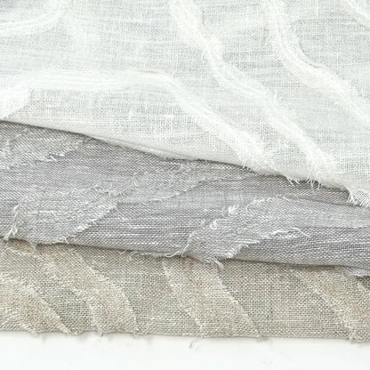 Three pieces of textured fabric in white, gray, and beige on a white background