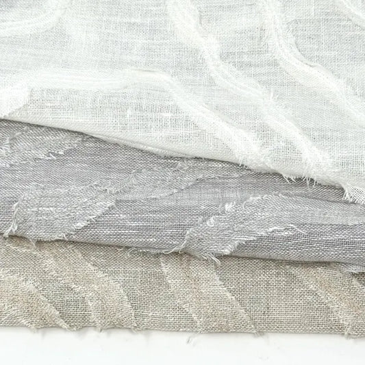 Three pieces of textured fabric in white, gray, and beige on a white background