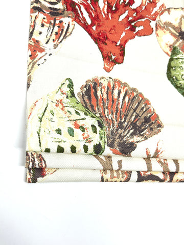 Linen fabric roman shade with colorful coral, shells, and marine life on white background