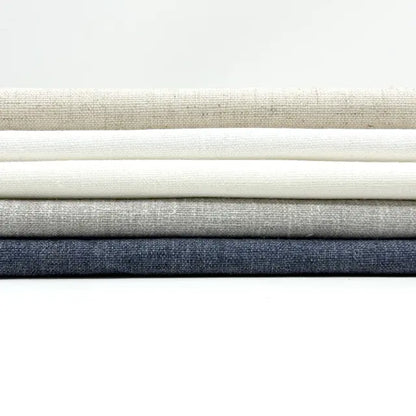 Stack of fabric swatches in various neutral colors on a white background
