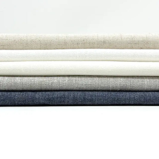 Stack of fabric swatches in various neutral colors on a white background