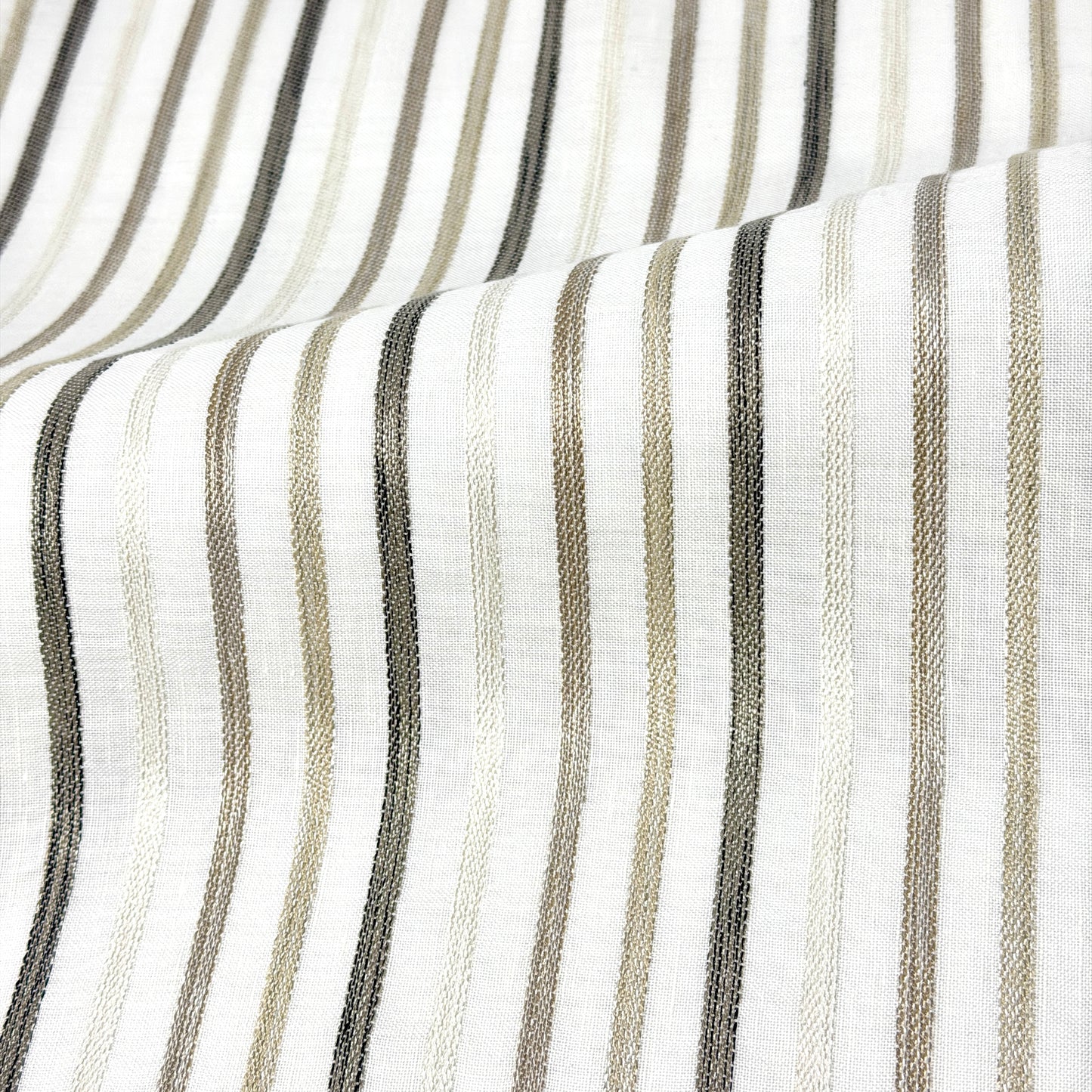 Close-up of fabric with vertical stripes in black, gray, and beige on a white background