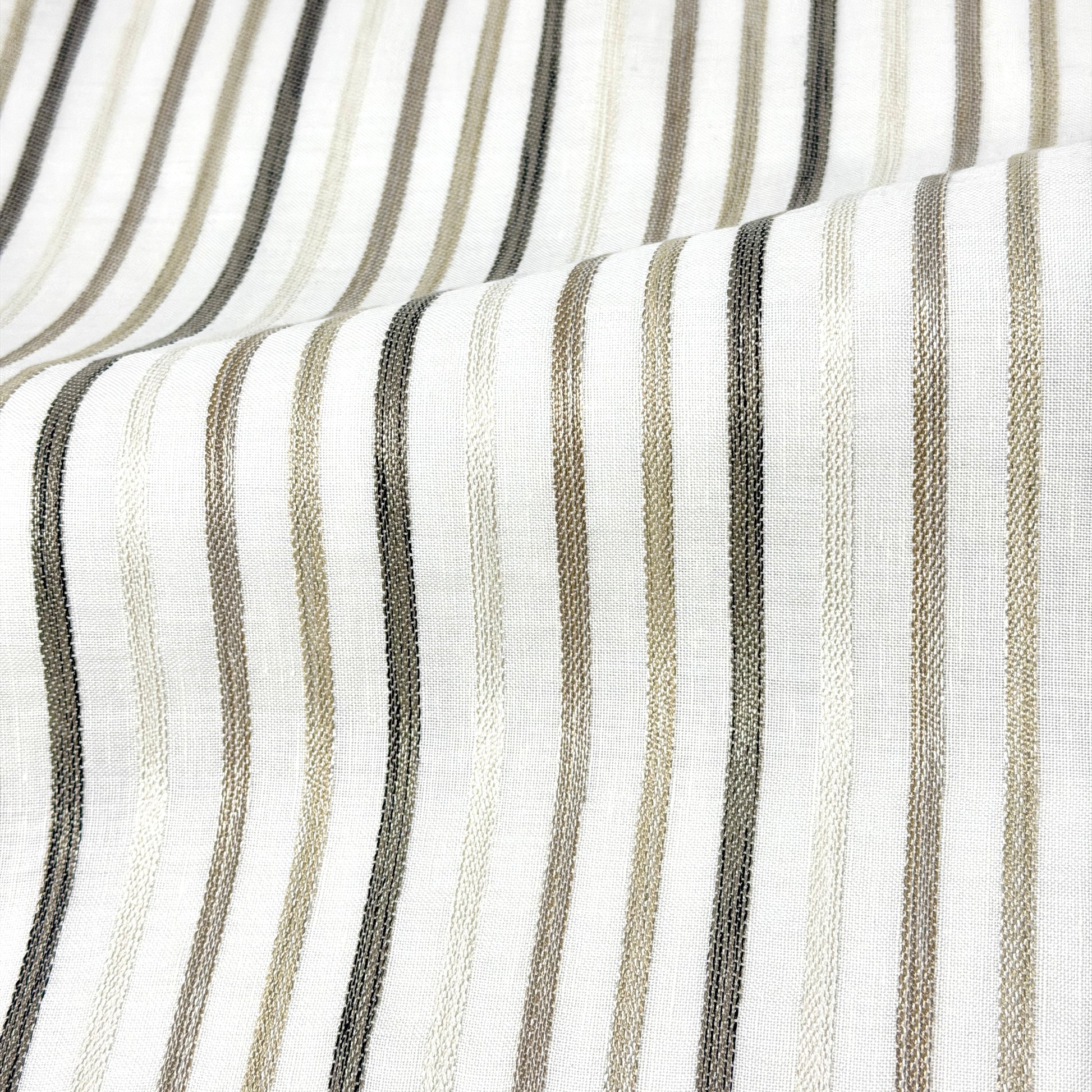 Close-up of fabric with vertical stripes in black, gray, and beige on a white background