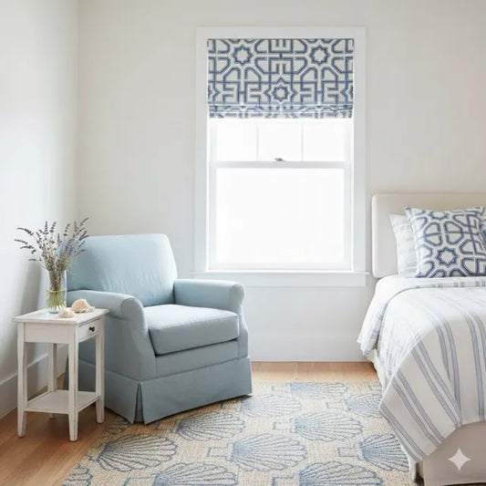 Cozy bedroom with light blue armchair, white bed, and decorative window treatment.