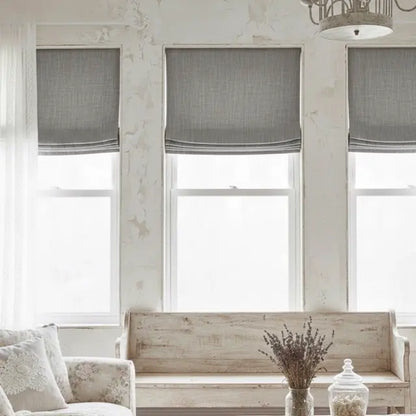Living room with gray window treatments and a wooden bench.