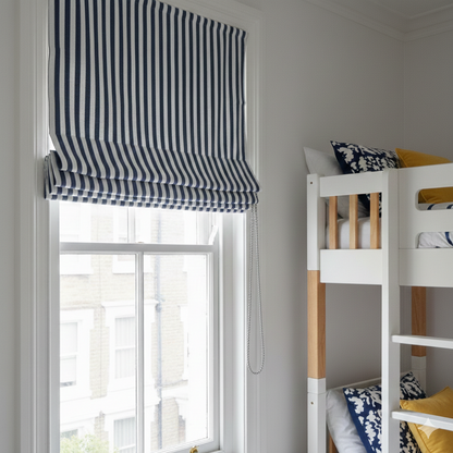 Navy and white striped roman blind on a window with a bunk bed in the background.