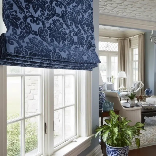 Blue damask Velvet roman blind in a room with a view of a living area.