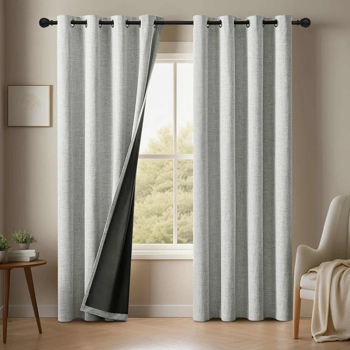 Gray curtains with black trim hanging in a room with a window and chair.