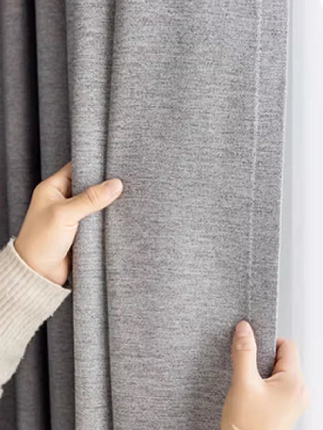Person holding gray fabric with a textured surface