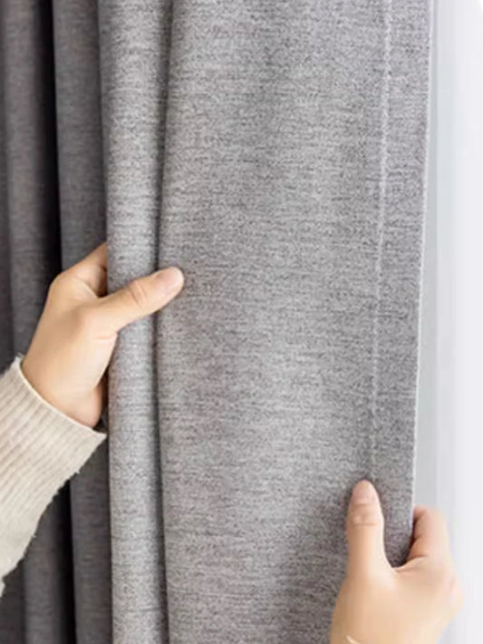 Person holding gray fabric with a textured surface