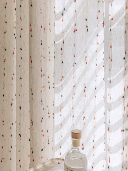 Glass bottle with a wooden cap against a patterned curtain
