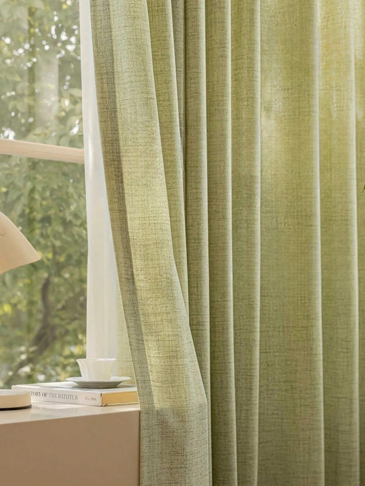 Green curtain with a blurred indoor setting and window in the background