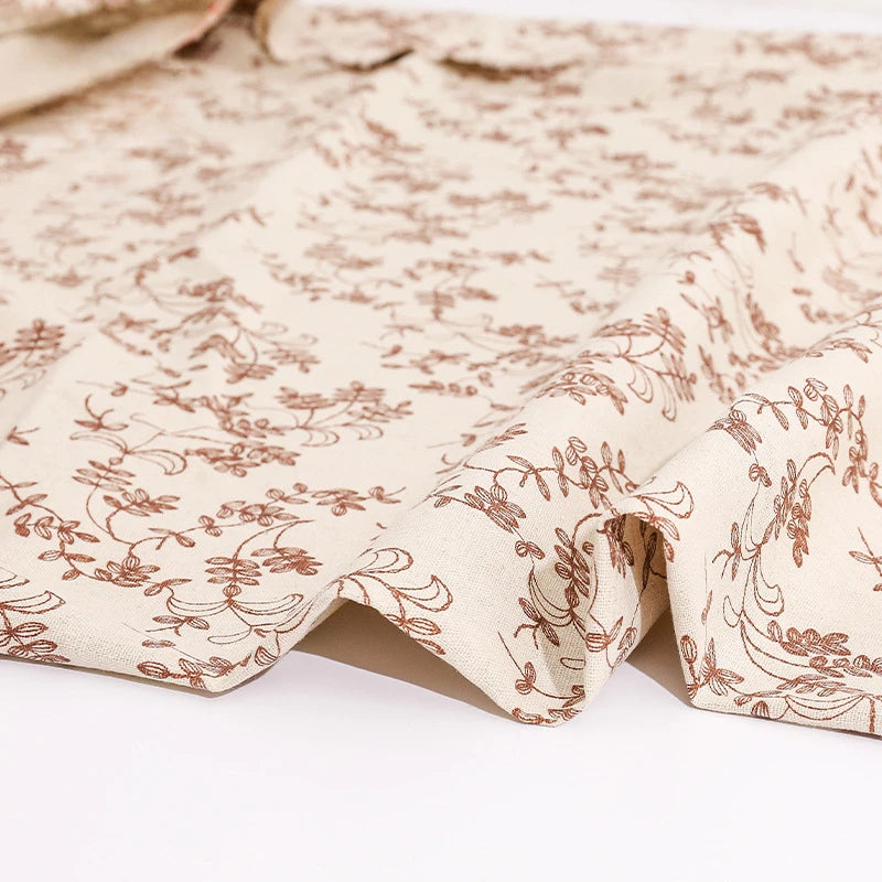 Floral patterned fabric with brown design on a white background